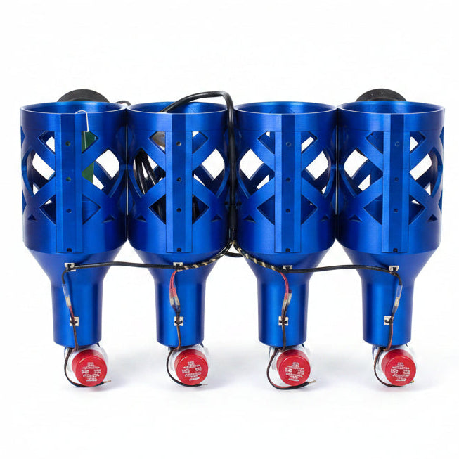 Four blue lacrosse strung bags on a wooden floor against a plain wall.